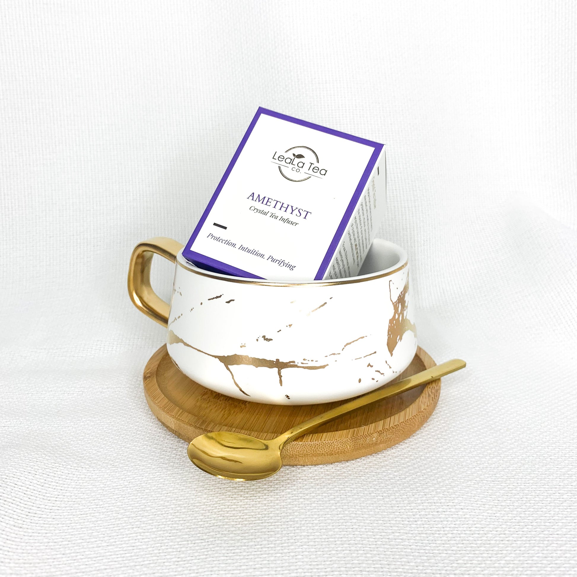 Athella Amethyst Crystal Infuser box packaging inside Boho Luxe White and Gold Teacup with Wooden Coaster and Gold Spoon.