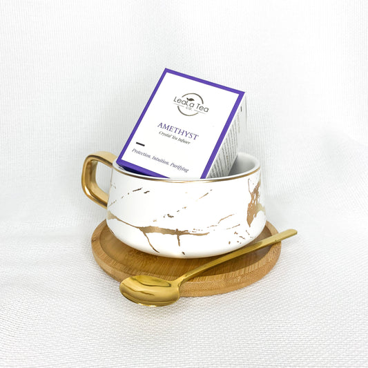 Athella Amethyst Crystal Infuser box packaging inside Boho Luxe White and Gold Teacup with Wooden Coaster and Gold Spoon.