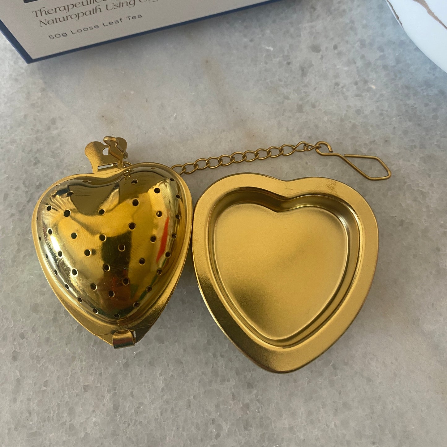 Athella Heart Shaped Tea Strainer next to Resting Plate