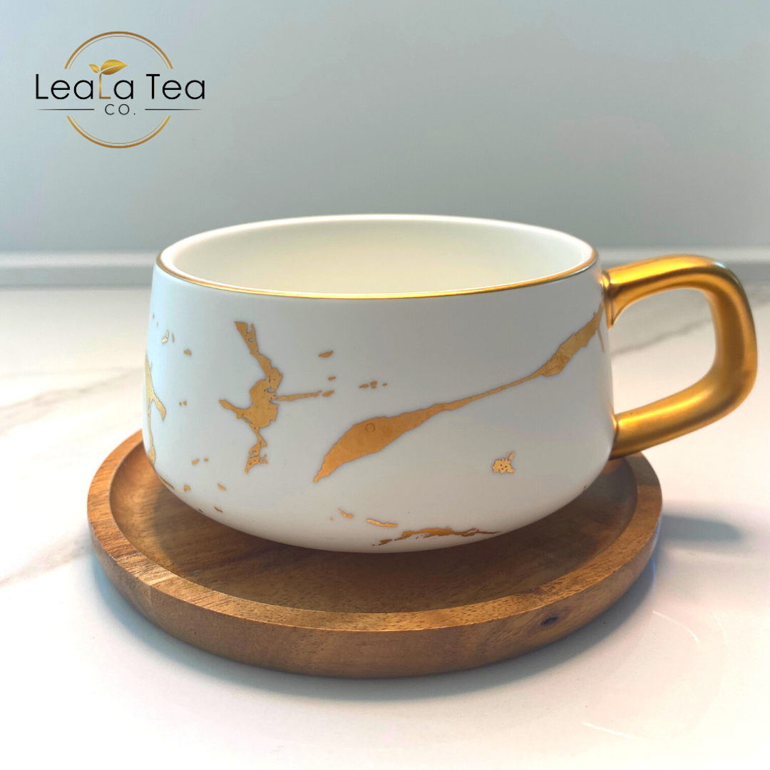 White and Gold Athella Boho Luxe Tea Cup on a Wooden Coaster