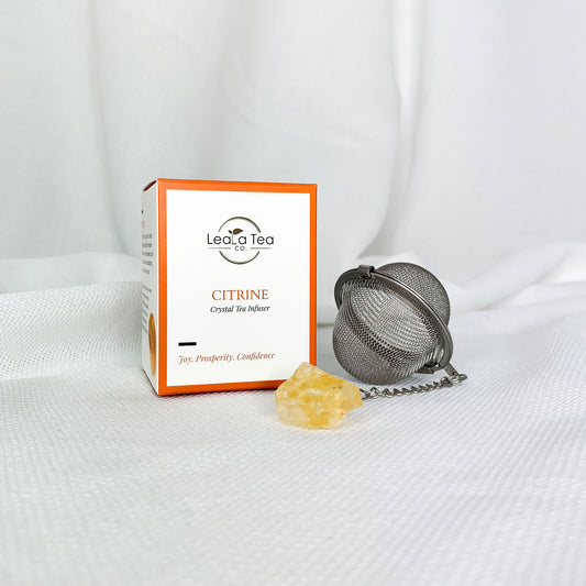 Athella Citrine Crystal Tea infuser, Joy, Prosperity, Confidence box packaging next to round Citrine Crystal Tea Infuser with Citrine at end of chain.