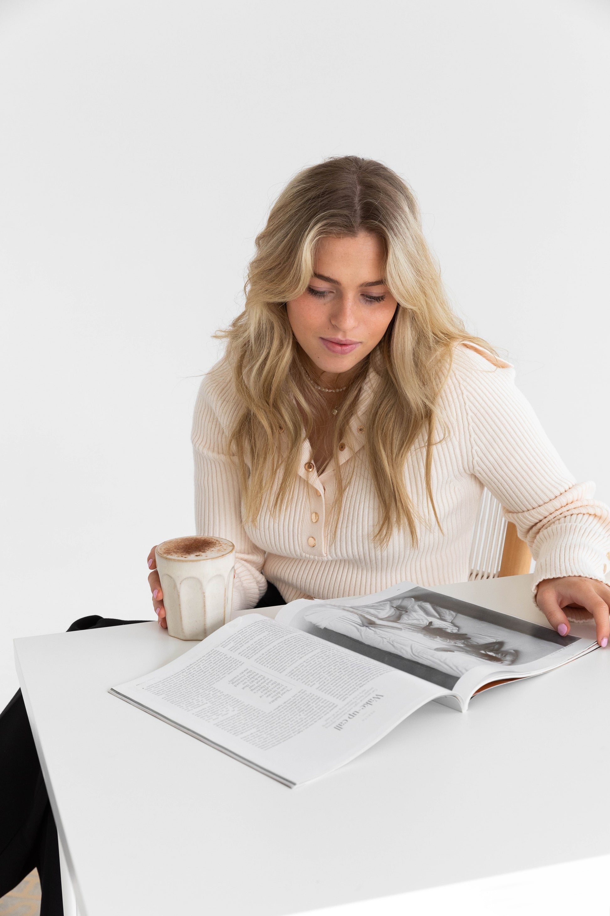 Girl with cup of Chai Collagen Latte reading a magazine. 