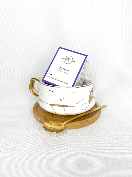 Athella Amethyst Crystal Infuser box packaging inside Boho Luxe White and Gold Teacup with Wooden Coaster and Gold Spoon.