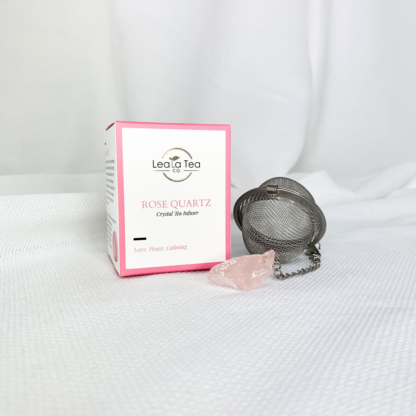 Athella Rose Quartz Crystal Tea Infuser, Love, Peace, Calming box packaging next to round Rose Quartz Tea Infuser product.